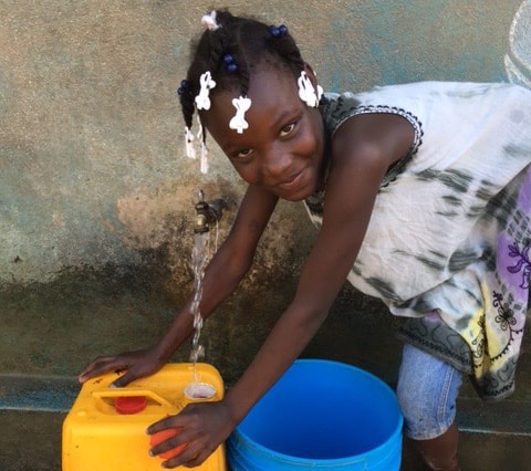 little girl next to water spout